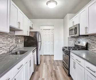kitchen with gas range oven, dishwasher, stainless steel microwave, light hardwood flooring, white cabinets, and dark stone countertops, The Park View At 320