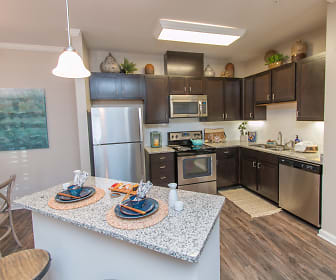 kitchen with stainless steel appliances, electric range oven, dark brown cabinets, pendant lighting, light granite-like countertops, and light hardwood floors, Parc at Broad River