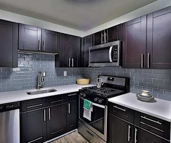 kitchen with stainless steel appliances, gas range oven, light flooring, dark brown cabinetry, and light countertops, Willow Run at Mark Center