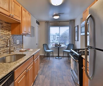 kitchen featuring natural light, stainless steel appliances, gas range oven, dark parquet floors, light granite-like countertops, and brown cabinets, Chesapeake Glen Apartment Homes