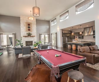 recreation room with a wealth of natural light, a high ceiling, hardwood flooring, a fireplace, refrigerator, and exhaust hood, Carrington Oaks