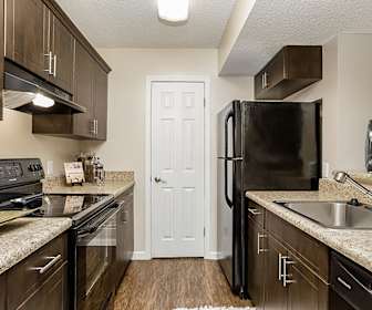 kitchen with electric range oven, exhaust hood, refrigerator, dishwasher, dark parquet floors, light stone countertops, and dark brown cabinets, Tuscany Pointe at Somerset Apartment Homes