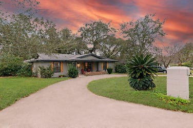 Front of house showing the circular driveway with sunset.JPG